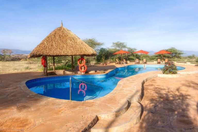 Basen Samburu Sopa Lodge, altana z pomarańczowymi kołami ratunkowymi i czerwone parasole z widokiem na busz