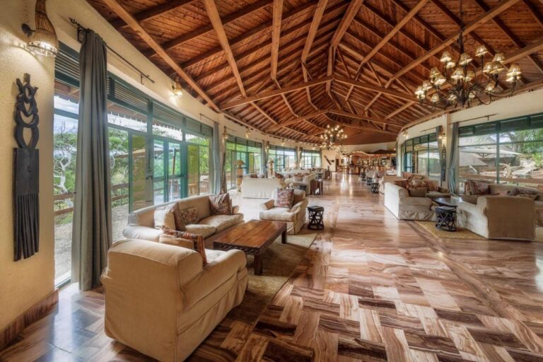 Duży salon obiektu z fotelami i przeszkleniami pod drewnianą więźbą